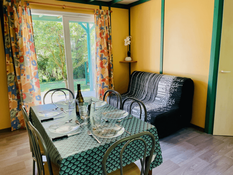 Coin salon avec canapé. Location Chalets en Ariège, chalets Epicéa conforts 6 personnes
