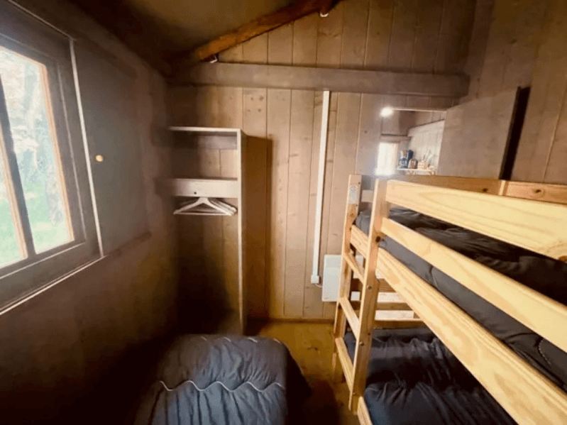 Chambre avec 3 lits dont 1 lit superposé du Lodge Èrable Confort. Le glamping à Camon en Occitanie