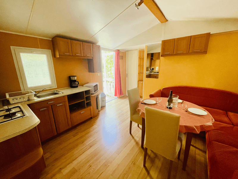 Coin cuisine salon avec banquette. Location mobil-homes en Ariège à Camon, mobil-home Chêne confort 4 personnes 