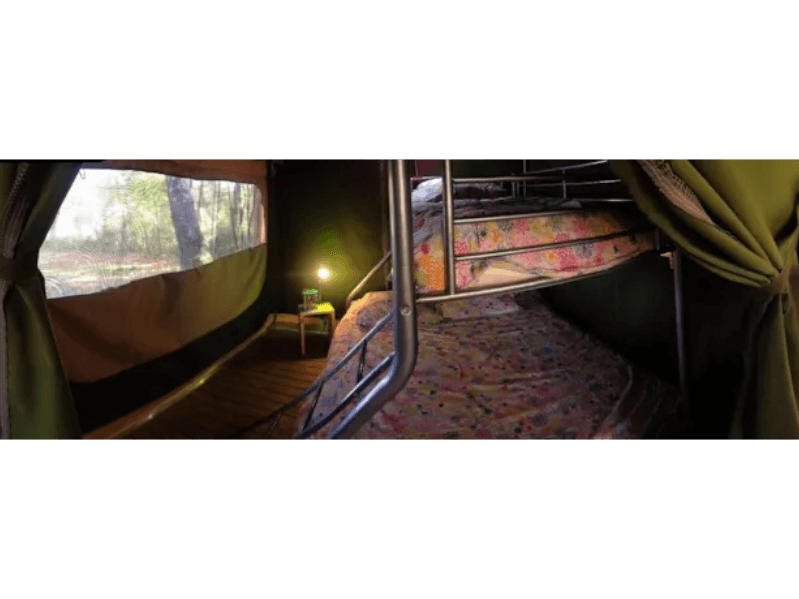 Chambre avec 3 lits et un lit superposé de la tente Safari Accacia Standard. Le glamping en Ariège
